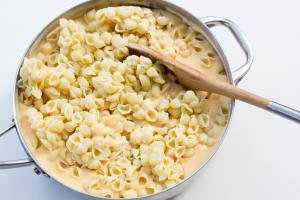 macaroni being mixed into the cheese mixture in the deep skillet