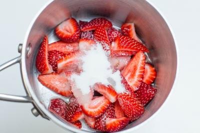 water, sugar and strawberries in a pot