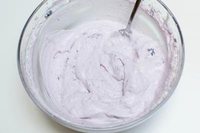 Heavy whip and crushed blueberries whisked together in a bowl
