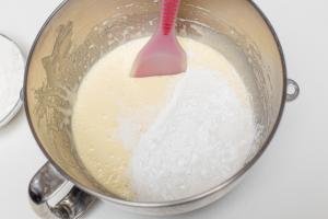 Flour being added into the mixing bowl with the egg mixture