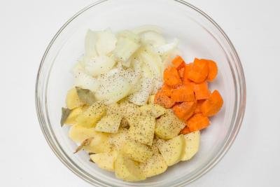 Cut up onions, carrot and potatoes, seasoned in a bowl