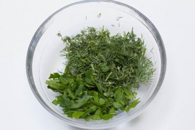 Parsley and dill chopped up in a bowl