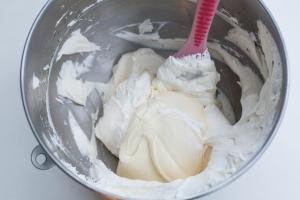 Cream mixture being combined with a spatula in a mixing bowl