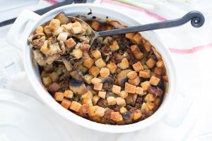 The Perfect Stuffing in a ceramic baking dish with a large spoon in it