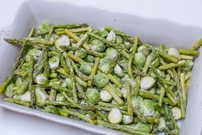 Seasoned brussels and asparagus in a baking dish