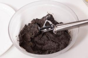 Oreo mixture being scooped out of a bowl with an ice cream scooper