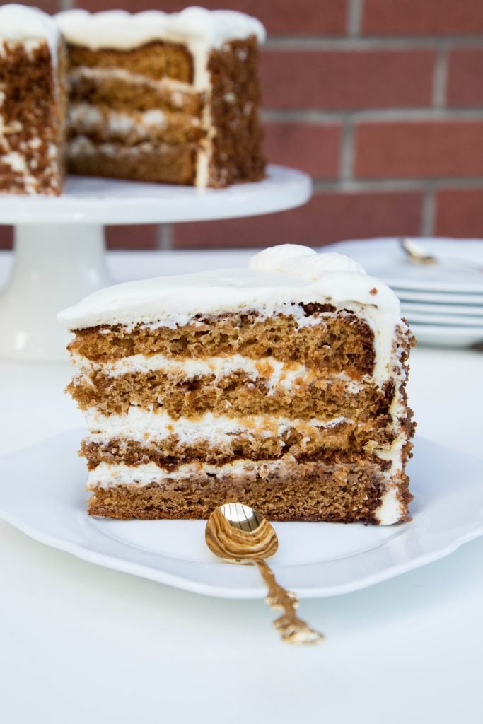 A slice of Jam Layered Honey Cake on a plate with a spoon next to the slice