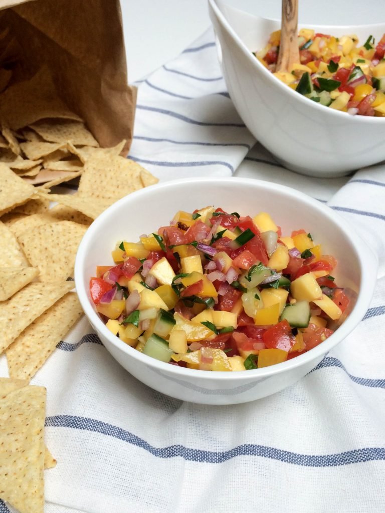Mango Salsa in a bowl with chips next to the bowl
