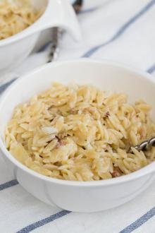 Creamy Orzo Bacon Pasta in a small bowl with a spoon in the pasta