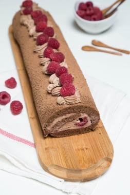 Raspberry Chocolate Roll on a long rectangular cutting board