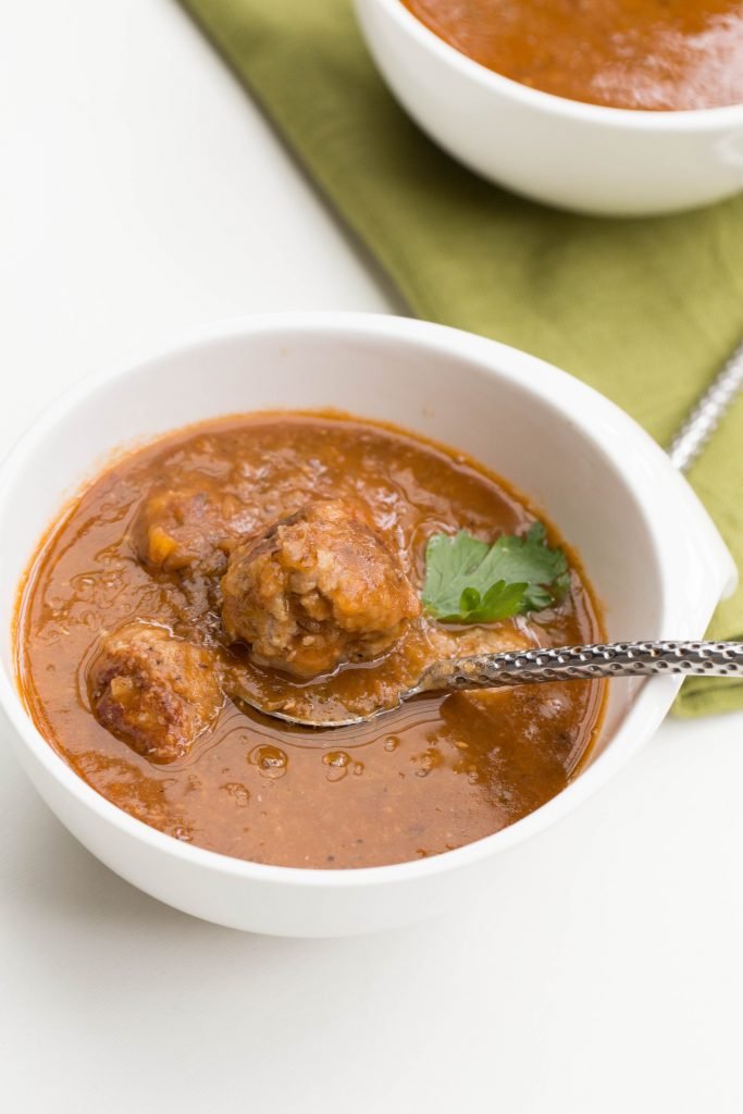 Tomato Lentil Soup with Meatballs in a bowl with a spoon