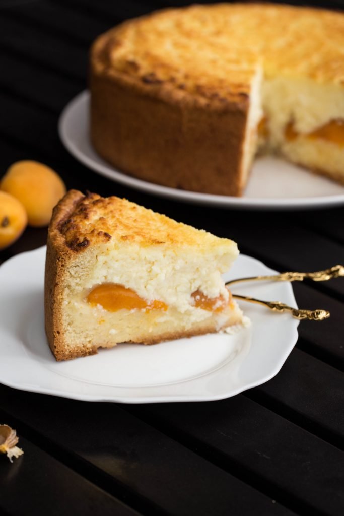 Apricot Farmer Cheese Cake slice on a plate with a spoon next to it