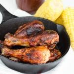 BBQ Chicken in an iron cast skillet with corn on the side