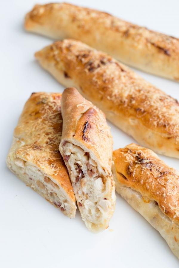 Chicken Bakes on the table, one cut in half and the rest full