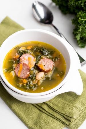Sausage Kale Soup in a bowl standing on a kitchen towel