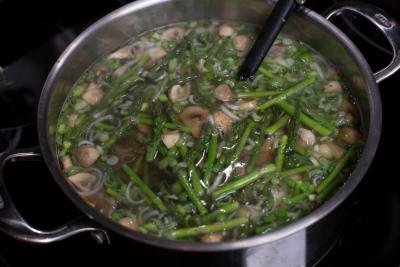 Asparagus, green onion, and mushrooms added into the pot with broth
