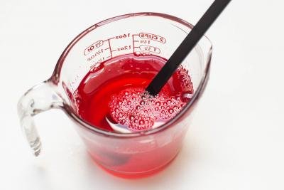 Strawberry Jello being mixed in a measuring cup