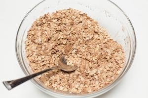 Oatmeal, sliced almonds and cocoa powder mixed in a bowl
