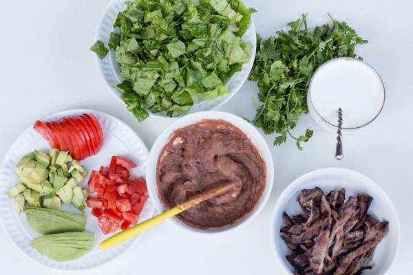 All ingredients for Tortilla Salad cut up and places into bowls and plates