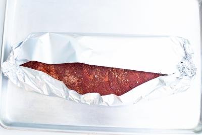 Dry rubbed ribs being wrapped oil foil