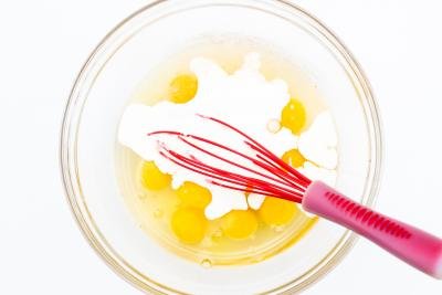 whipping cream and eggs in a bowl with a whisk