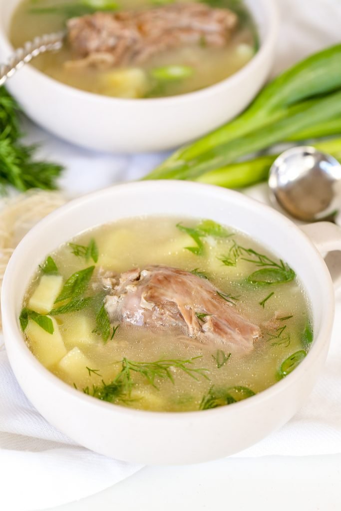 Cooked turkey neck in a bowl of soup.