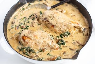 Skillet with chicken in a creamy sauce.