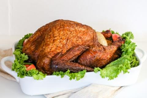 Smoked turkey on a serving dish with garish around it