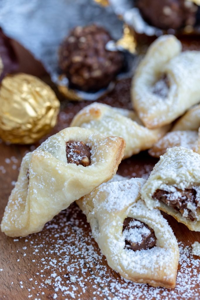 cookies on a wooden board with candies in background