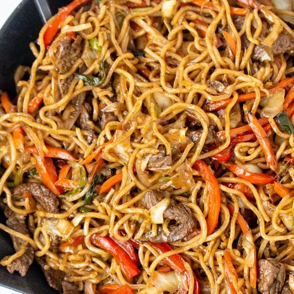 Yakisoba in a wok with a spoon