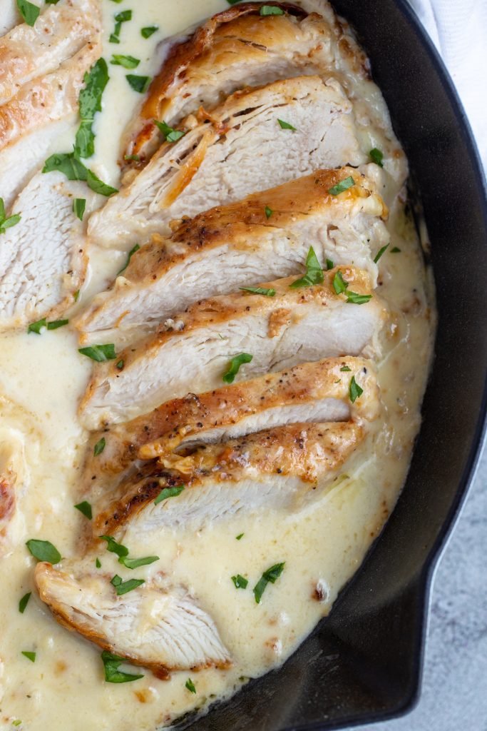 Chicken in a skillet with creamy sauce