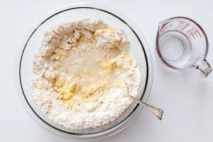 Flour, eggs and water in a bowl with flour