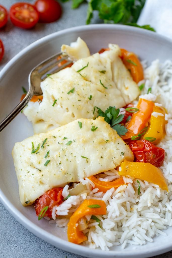 Plate with baked cod and plate with rice