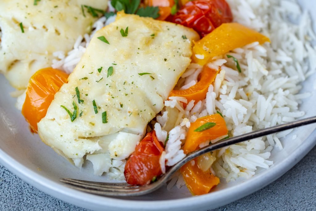 Plate with baked cod and plate with rice