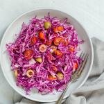 purple salad in a bowl with fork and towel next to it