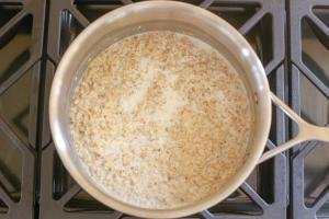 Old fashioned oatmeal with milk in a cooking pot
