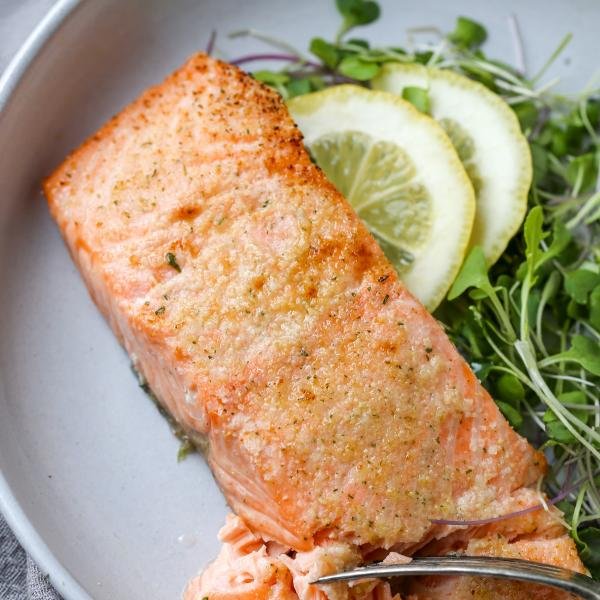 Air Fryer Salmon in a plate with greens
