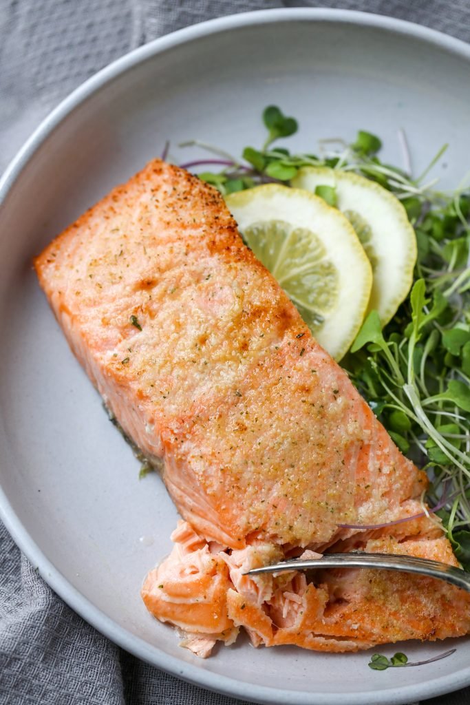 Air Fryer Salmon in a plate with greens