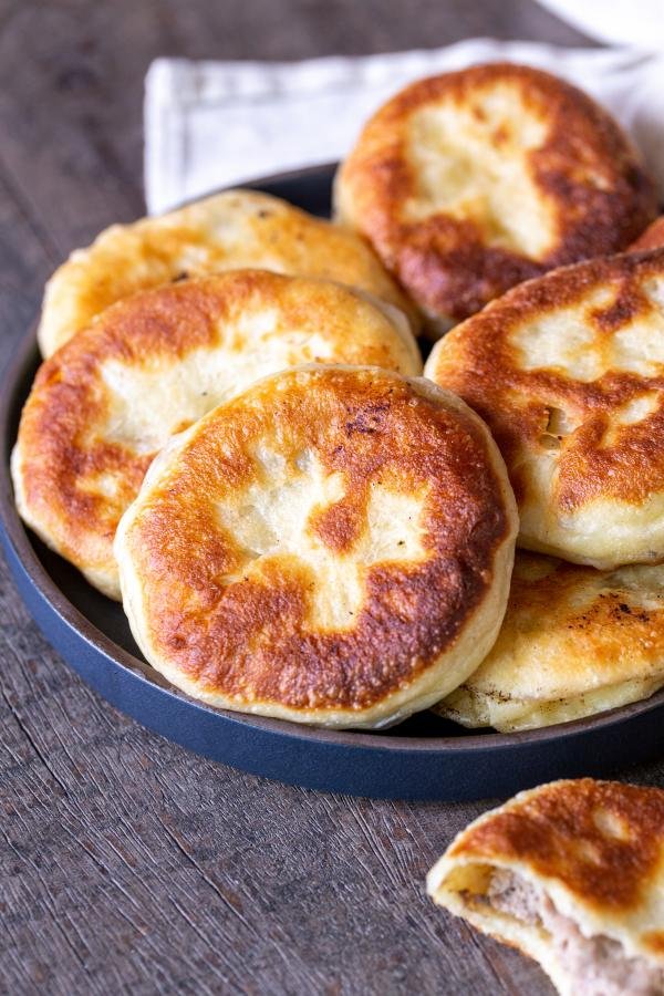 Piroshki in a bowl with another one next to the bowl