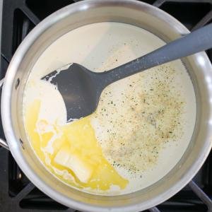 Pot with cream butter and seasoning on a cook top
