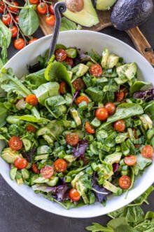 Garden Salad in a serving bowl with veggies around it.