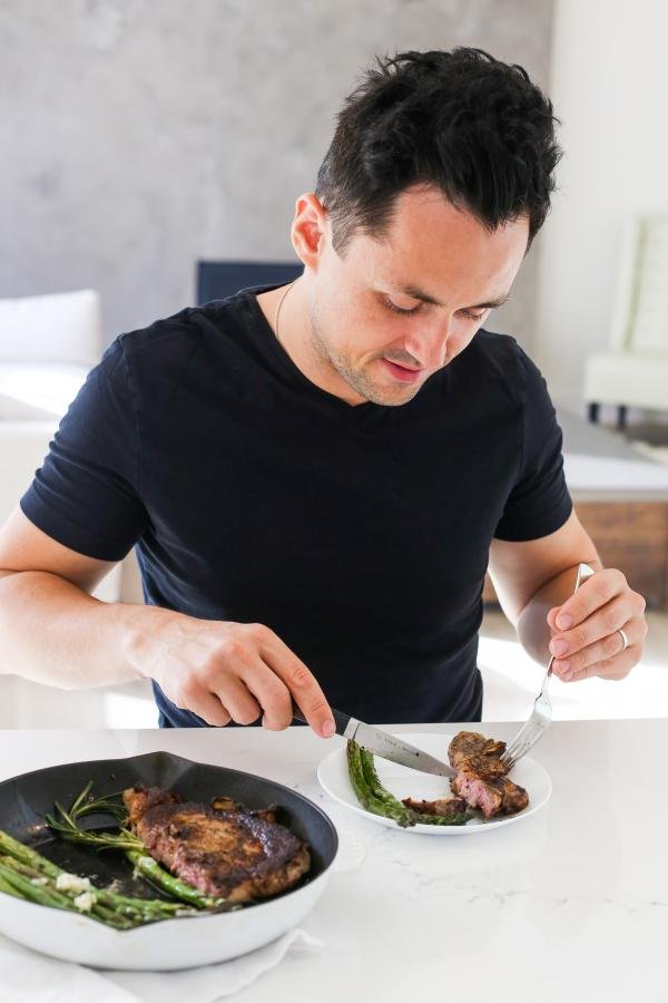 Tim cutting ribeye in a plate