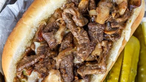 Philly Cheesesteak Sandwich in a tray with pickles