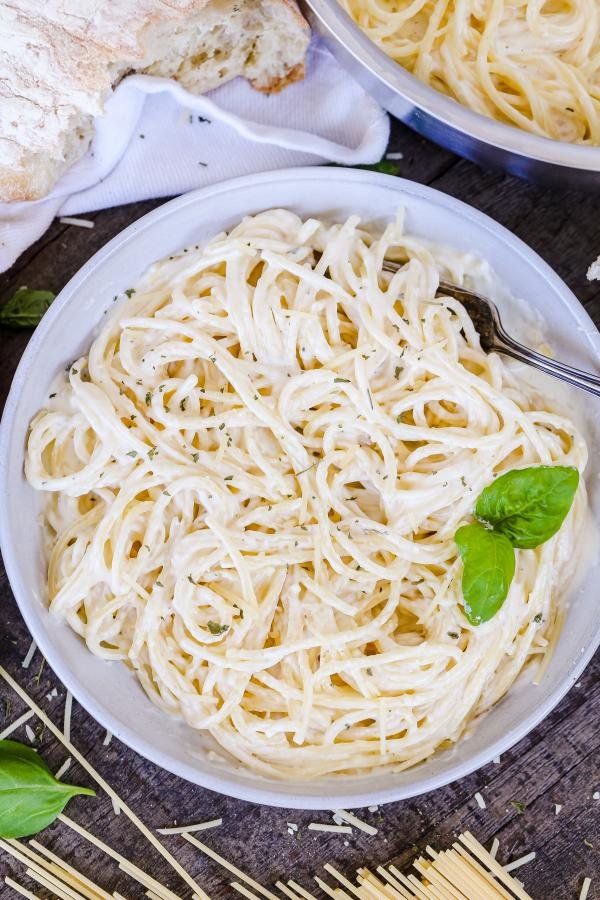 Alfredo Pasta in a bowl with pasta ingredients  around 