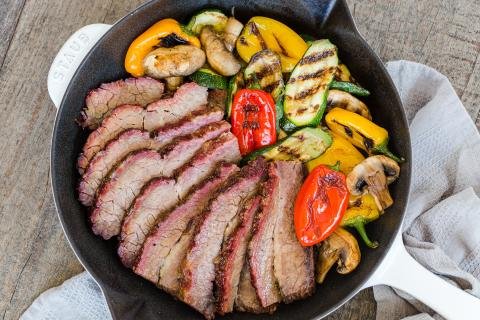 Brisket in a skillet with grilled veggies