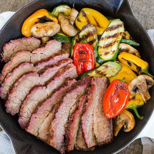Brisket in a skillet with grilled veggies