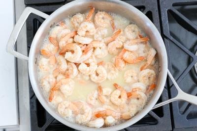Cooking shrimp in a skillet with sauce
