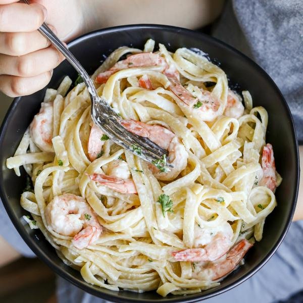 Creamy shrimp scampi in a hand a child