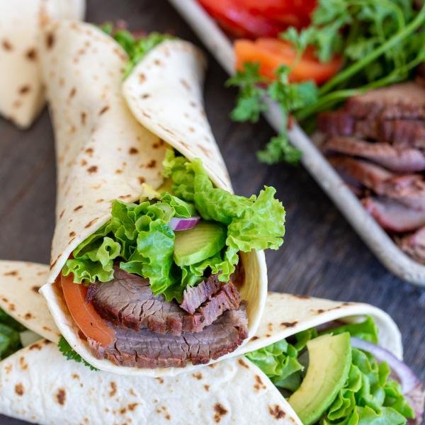 Flank wraps and a tray with veggies and flank in background