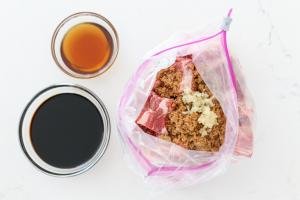 Ziplock bag with with ribs and marinade soy case and sesame oil in a bowl